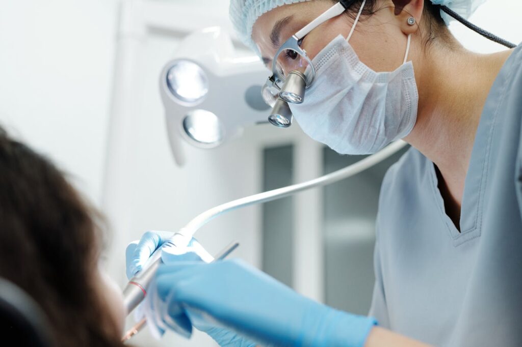 Close-up of a dentist wearing magnifying glasses, performing a dental procedure in a modern clinic.